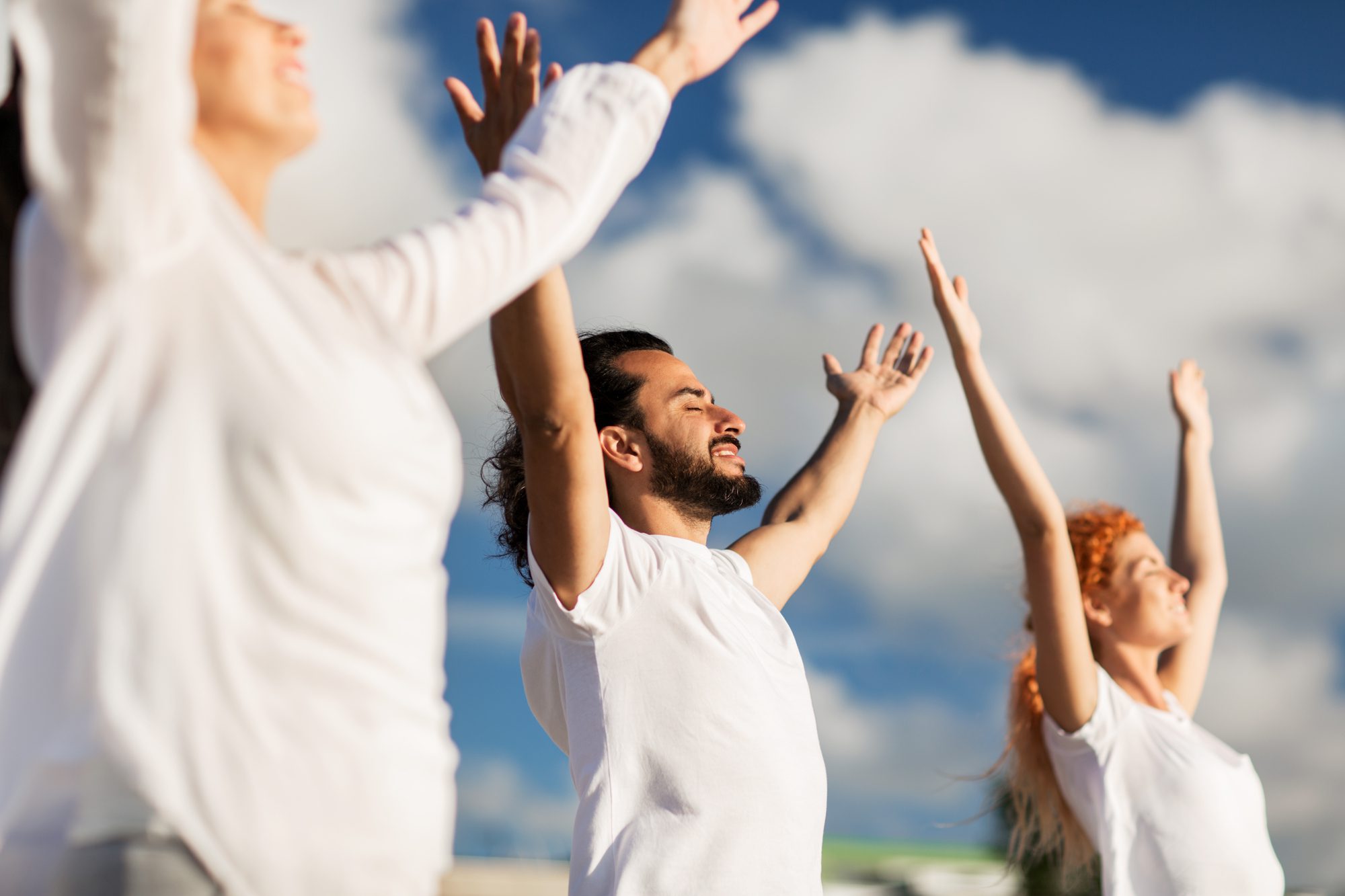 Group of people making yoga exercises outdoors